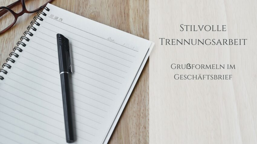Grußformeln im Geschäftsbrief: Holztisch mit Notizblock, darauf ein schwarzer Stift, daneben eine Brille